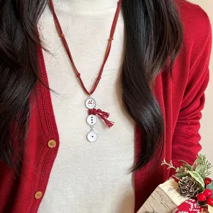 Collar de muñeco de nieve con borla roja sobre un cárdigan festivo rojo brillante