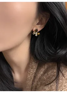 Close-up of elegant butterfly stud earrings with tiger eye stone and zircon