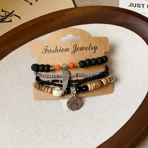 Detail view of a multi-layer beaded bracelet featuring wood beads and wing charm
