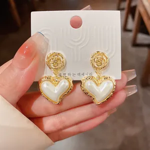 Vintage Baroque style gold pleated flower earrings featuring a pearl heart design detail
