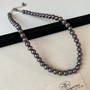 Detailed macro shot of an elegant vintage-style grey pearl necklace on a display board
