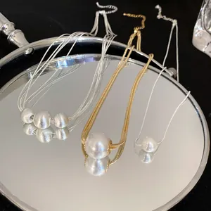 Close-up of minimalist pearl necklaces with mirror reflections in gold and silver