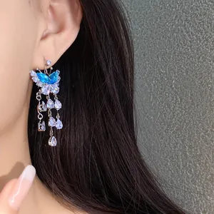 Dettaglio di un orecchino a farfalla scintillante con nappe in zircone blu e gocce d'acqua