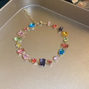 Detailed macro shot of vibrant multi-colored geometric zircon crystals on gold chain bracelet