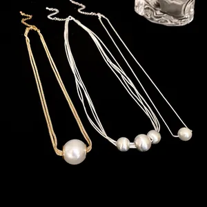 Detail view of French Baroque pearl pendant necklaces in gold and silver finishes