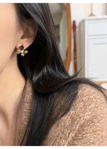 Detailed close-up view of a butterfly stud earring with zircon and tiger eye stone inlay