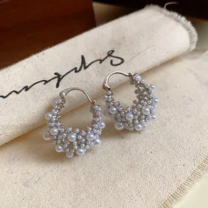 Vue détaillée de créoles élégantes plaquées or 14 carats avec grappes de perles fines.
