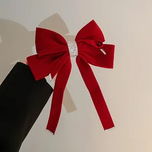 Elegant large red velvet bow hair clip with sparkling rhinestone center and long streamers