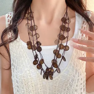 Retro ethnic style multi-layer necklace with irregular round coconut shell tassels on model