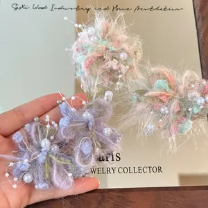 Detailed close-up of handmade yarn flower earrings with pearls and soft textures