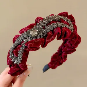 Close-up of red velvet ruffled headband with grey rhinestones and central crystal
