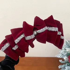Detailed view of a layered red velvet bow hair clip with pearls and crystal trim.