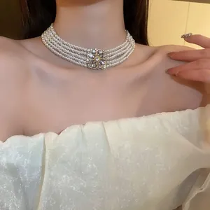 Close-up of a luxury retro multi-strand pearl choker necklace with a rhinestone centerpiece