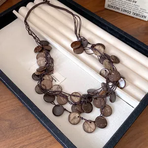Close-up of irregular round coconut shell pieces on a retro ethnic tassel necklace