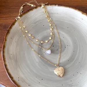 Elegante dreilagige goldene Herzkette mit Vintage-Medaillon und feinen Herzanhängern.