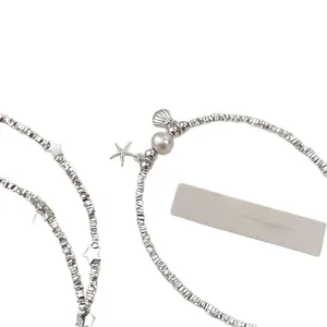 Minimalist silver-tone beaded bracelet featuring a white pearl and starfish shell charms