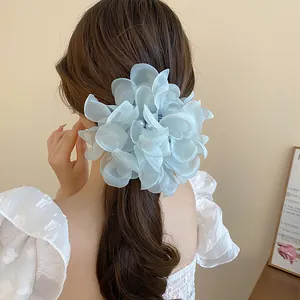 Detailed view of an elegant light blue orchid flower hair claw clip on brunette hair