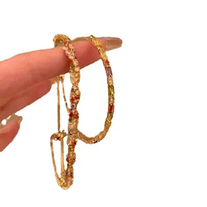 Bracciale rigido geometrico di lusso con pietre multicolori e cinturino regolabile.