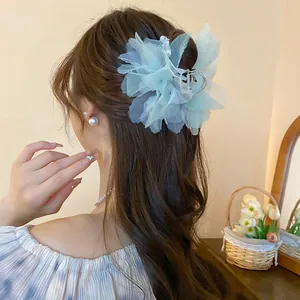 Close-up detail of mint green orchid floral hair claw clip elegantly worn on a stylish bun