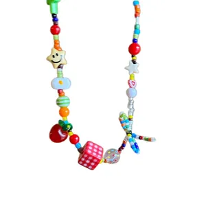 Handmade colorful beaded necklace with cute star smiley strawberry charms on white background