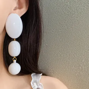 Dettaglio ravvicinato di orecchini pendenti in acrilico bianco stile retrò vintage