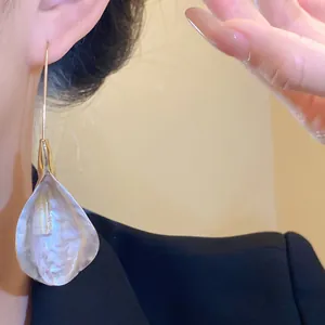 Primo piano di orecchini a pendente a forma di petalo vintage su una modella elegante