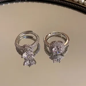 Elegante geometrische zilveren ringen met zirkonia op een reflecterend spiegeloppervlak