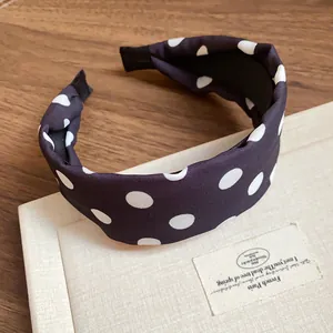 Vista de detalle de una elegante diadema de tela con lunares negros y blancos de moda