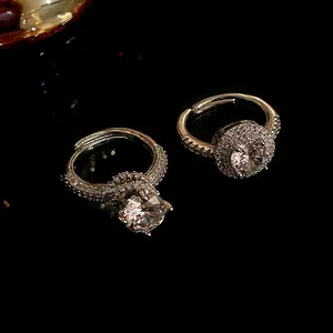 Elegante zirkoon ring met fonkelende pavé diamanten op een donker reflecterend oppervlak.