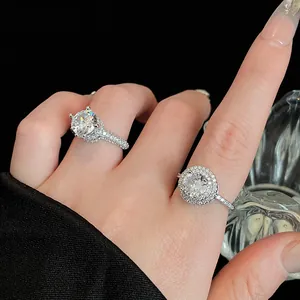 Detailopname van zilveren zirkonia ringen met halo en solitaire zettingen op de hand
