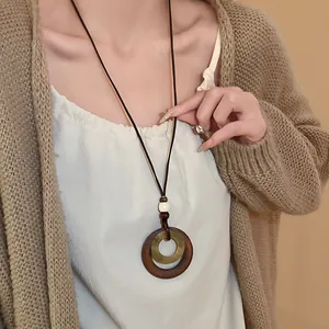 Close-up view of a retro geometric double-circle pendant necklace worn by a female model.