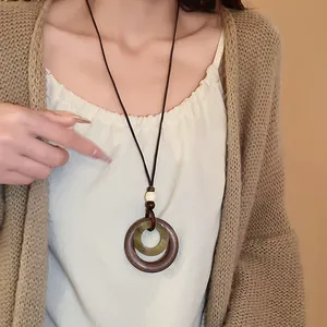 Long vintage ethnic style necklace with geometric faux wood and resin circle pendants.