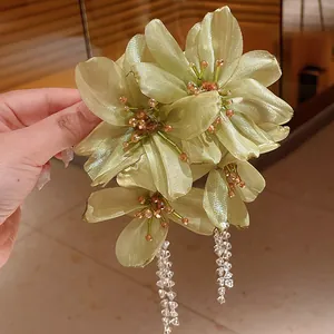 Detail of light green mesh flower earrings with shimmering crystal tassels