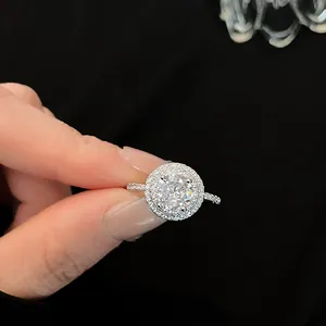 Gedetailleerde weergave van een elegante zilveren ring met ronde zirkoon en halo-zetting