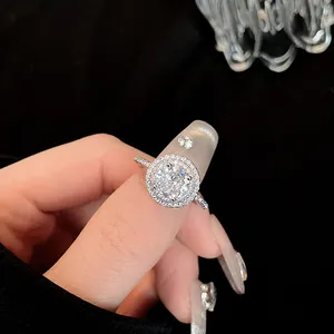 Detailopname van een zilveren halo-ring met fonkelende ronde zirkonia op de vinger