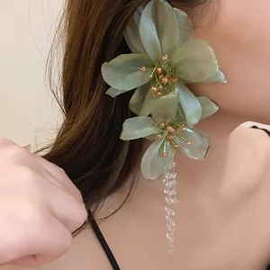 Detail showing delicate mesh flower petals and clear crystal tassels of the earring.