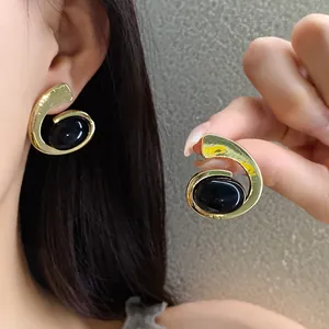 Boucles d'oreilles spirales géométriques vintage avec élégantes pierres ovales noires.