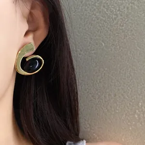 Gros plan sur des boucles d'oreilles spirales ovales géométriques de style vintage