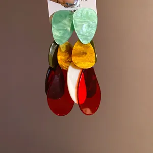 Macro view of bold multi-colored marbled acrylic teardrop earrings with S925 silver studs