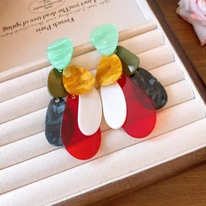 Detail view of vintage style colorful layered acrylic earrings in a beige gift box.