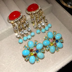Orecchini vintage a fiori con strass e nappe di pietre in un vassoio portagioie