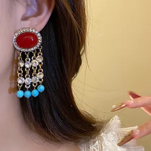 Orecchini vintage con ago d'argento, pietra rossa e nappe di cristallo all'orecchio.