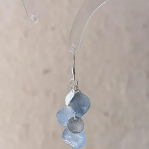 Detail view of elegant gradient blue shell petal earrings with textured silver disc accents
