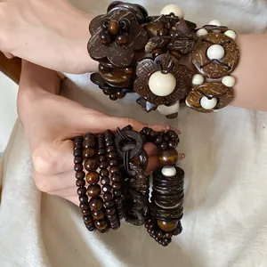 Primo piano di braccialetti etnici in perle di legno e guscio di cocco sul polso
