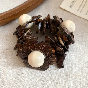 Dettaglio ravvicinato della trama di un bracciale etnico con legno e fiori di cocco