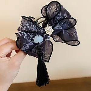 Detalle de pinza para el pelo con lazo, borla negra y estampado de bambú de estilo chino
