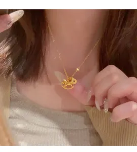Detailed close-up view of a gold rocking horse pendant necklace worn on a person's neck.