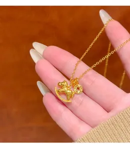 Detailed close-up of a golden rocking horse and coin charm necklace held in a hand