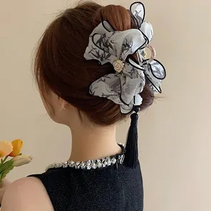 Detalle de pinza para el cabello de estilo chino elegante con borla de seda negra