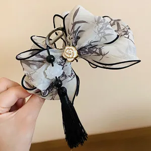 Detalle de una pinza para el pelo con lazo de estilo chino y borla negra